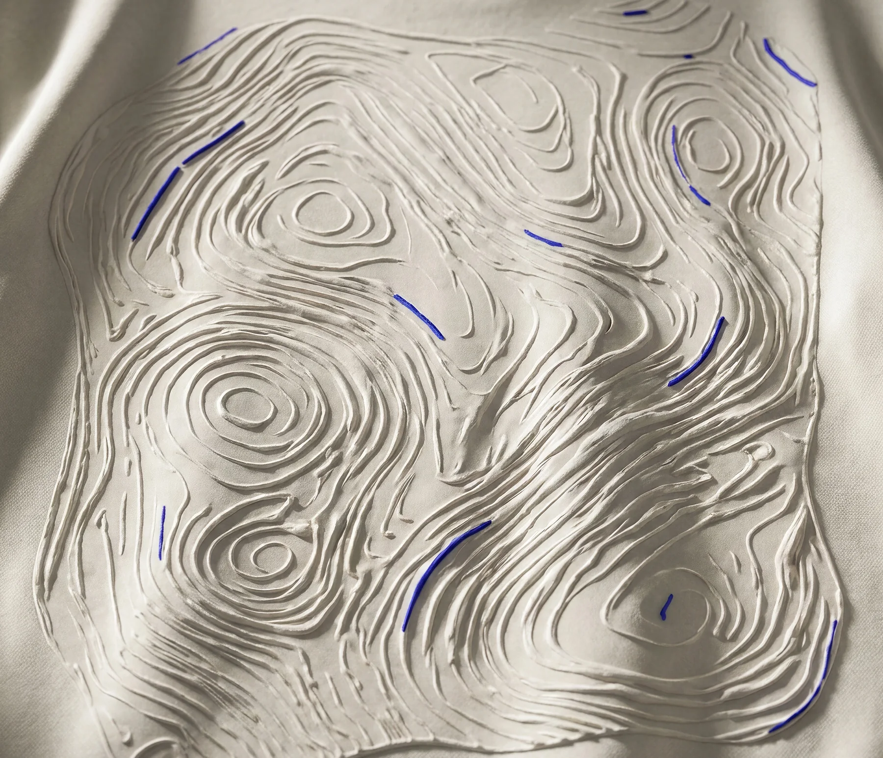 The topography worked into the surface, interrupted in cobalt.